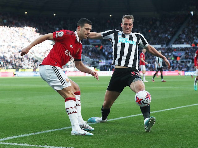 Dan Burn del Newcastle United en acció amb Diogo Dalot del Manchester United el 2 d'abril de 2023